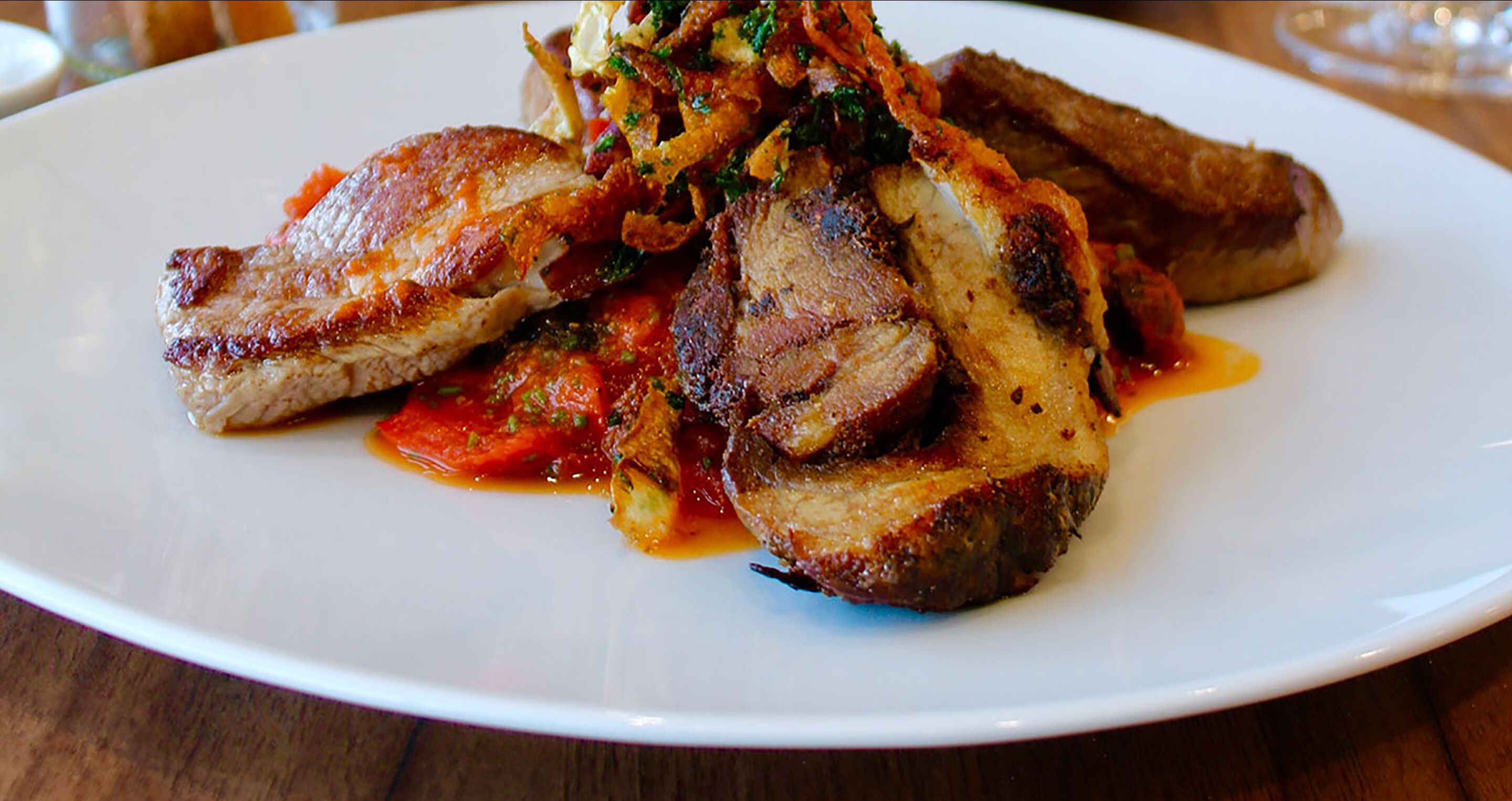A plate of food with roasted meat and vegetables.