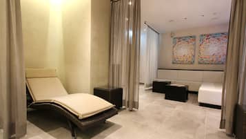 Relax in a serene space with a daybed, sofa, and ottoman, set against a large window with sheer curtains.