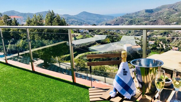 A terrace with a view of a hilly landscape, a bottle of champagne, and a metal bucket. - HR Mirador (Canillas de Albaida)