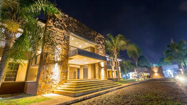 Un edificio de piedra con una entrada bien iluminada y escalones que llevan a ella.