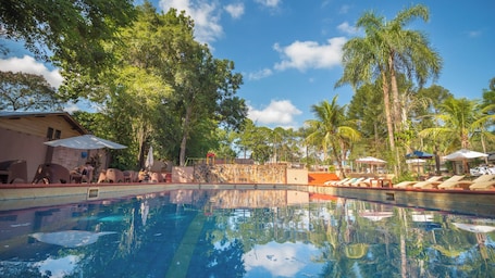 Una piscina al aire libre, sillones reclinables de piscina