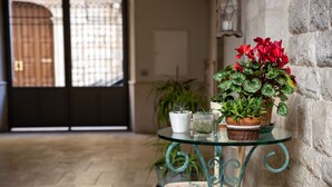 Una mesa de vidrio con plantas en macetas y un jarrón blanco.