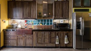 Una cocina con armarios de madera, un refrigerador de acero inoxidable y un salpicadero de azulejos.