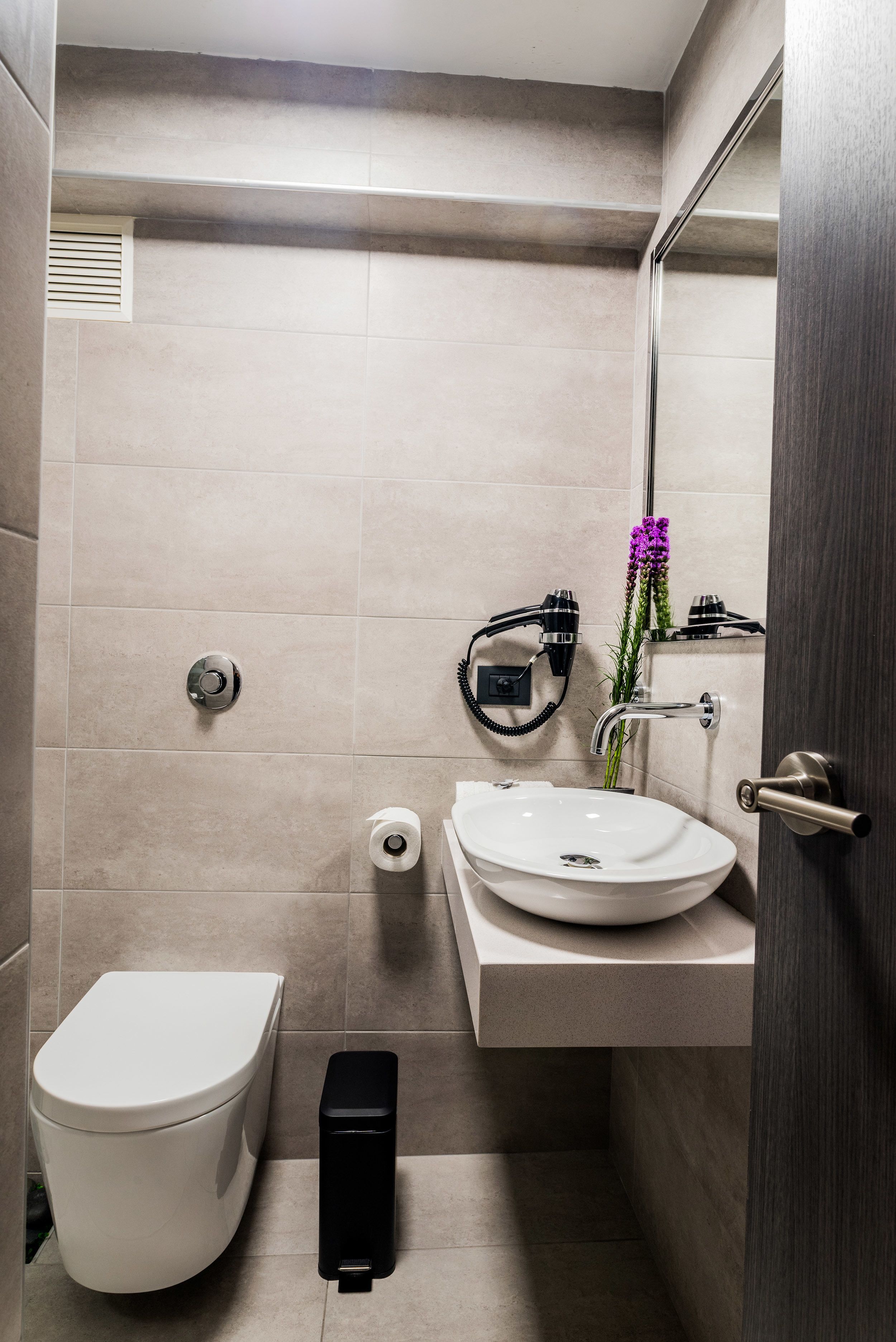 Un baño moderno con inodoro, lavabo y espejo.