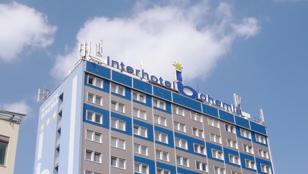 Un edificio de hotel con fachada azul y blanca, varias ventanas y una estrella en la parte superior.