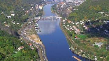 An aerial view of a river with a bridge, surrounded by residential areas and greenery.