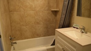 Une salle de bain avec une baignoire, un lavabo et un meuble-lavabo.
