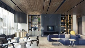 Een moderne woonkamer met een bank, stoelen, een televisie en boekenplanken.