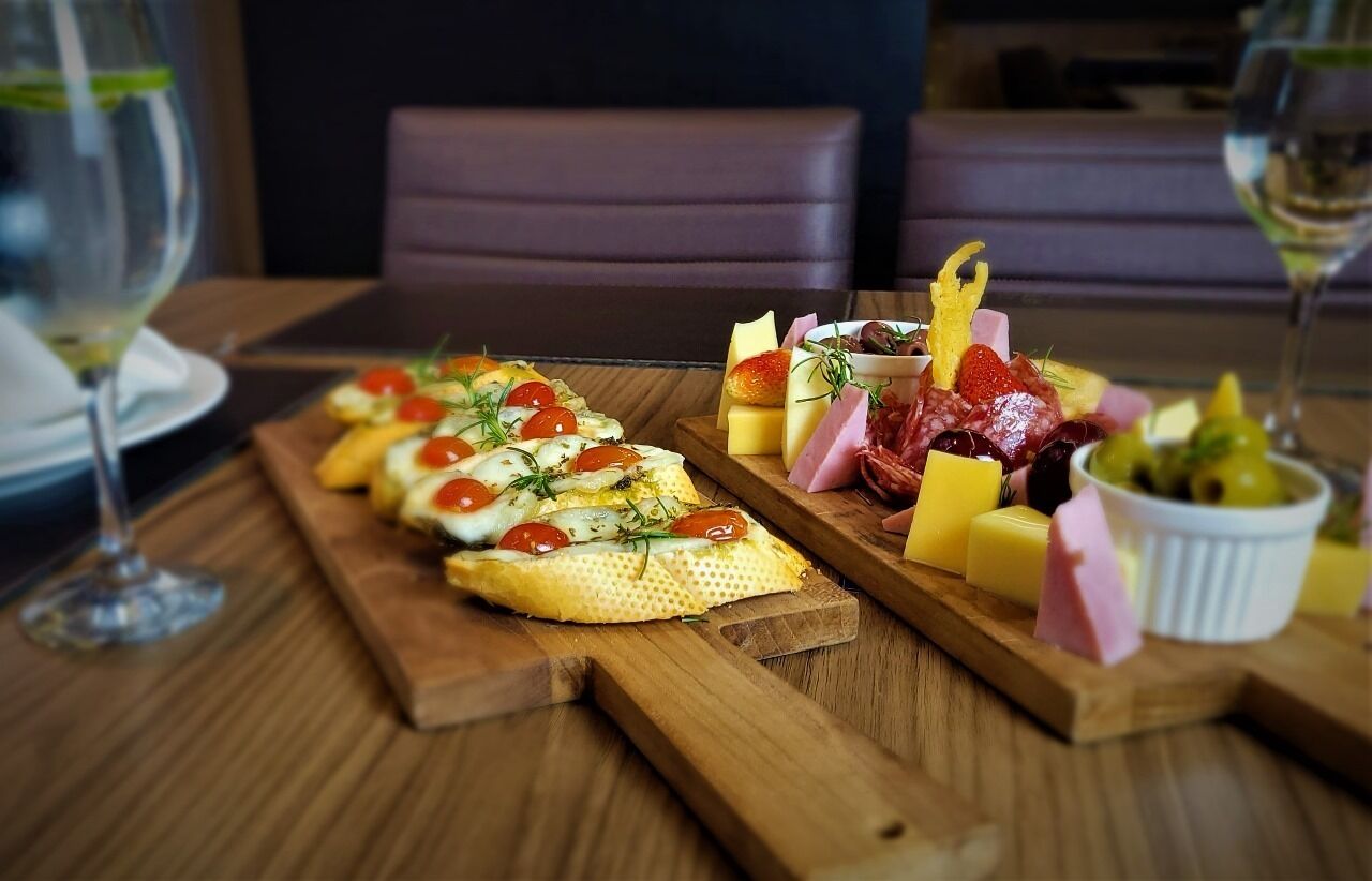 A wooden table with a variety of cheeses, cured meats, and charcuterie.