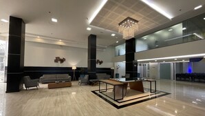 A spacious lobby with a high ceiling, a central chandelier, and a seating area with sofas and chairs. - Hotel Transamerica Maringá (Maringá)