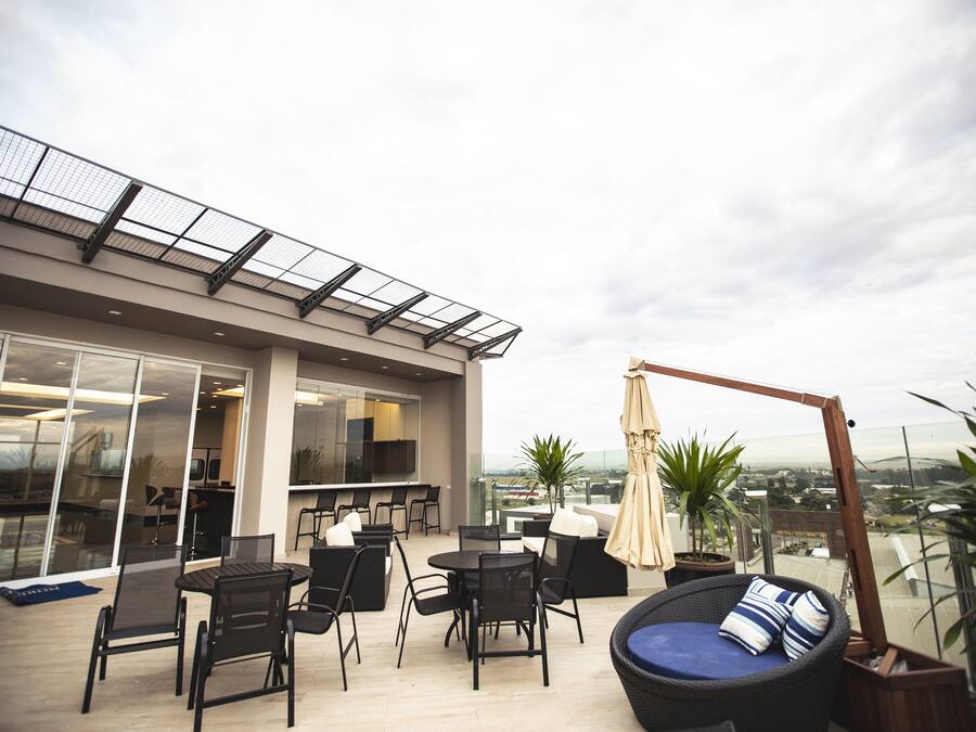 Une terrasse extérieure avec un espace repas, des sièges et une vue sur la ville.
