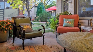 A patio with two chairs, one with a patterned cushion and another with a cushion featuring a cartoon character. - The Crest Motel in Colorful Colorado (Sterling)