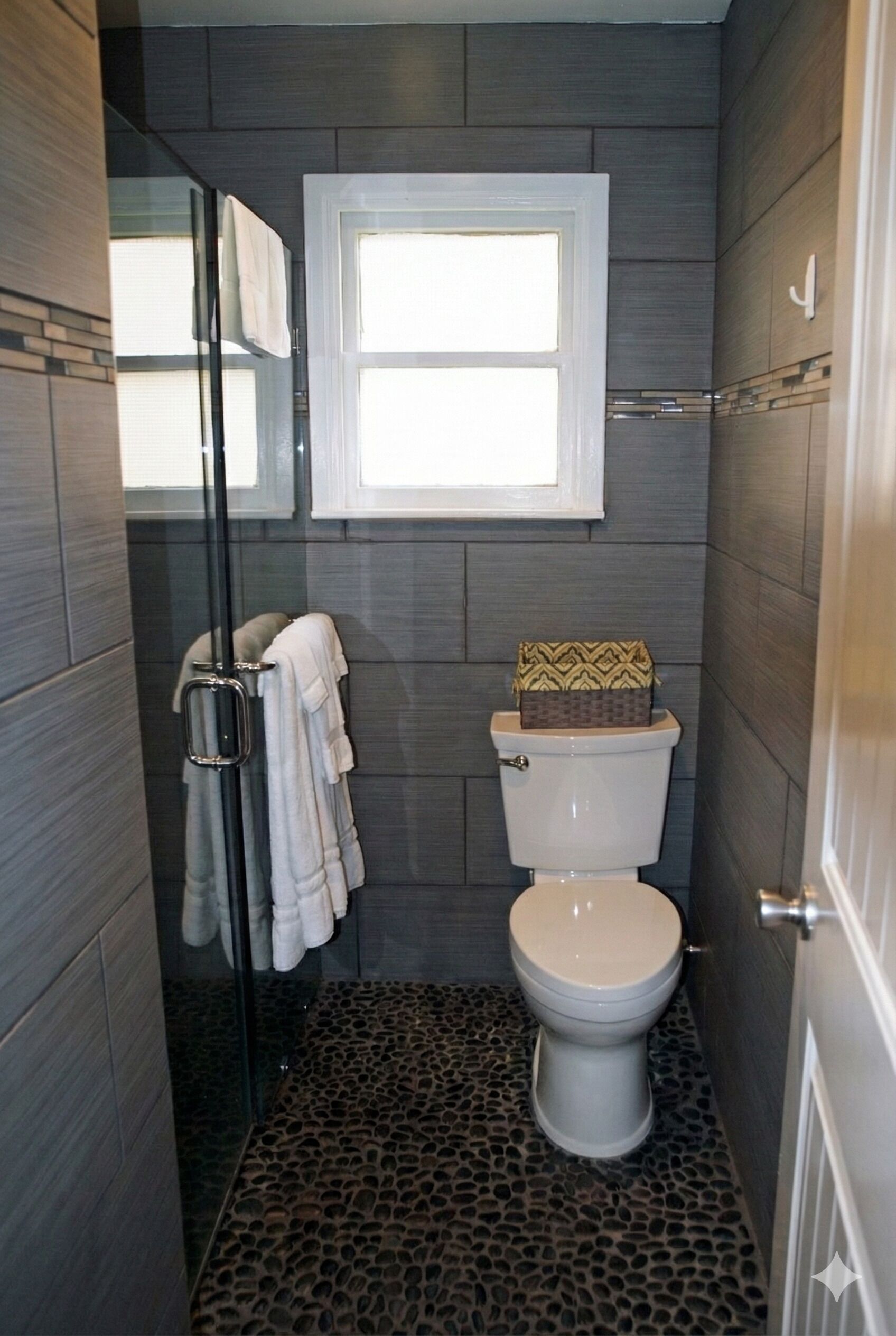 A bathroom with a toilet, a shower, and a window.