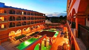 Un patio de hotel con varios niveles de arcos y una zona de piscina central.