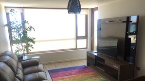 Apartamento família, várias camas, vista para a praia | Sala de estar