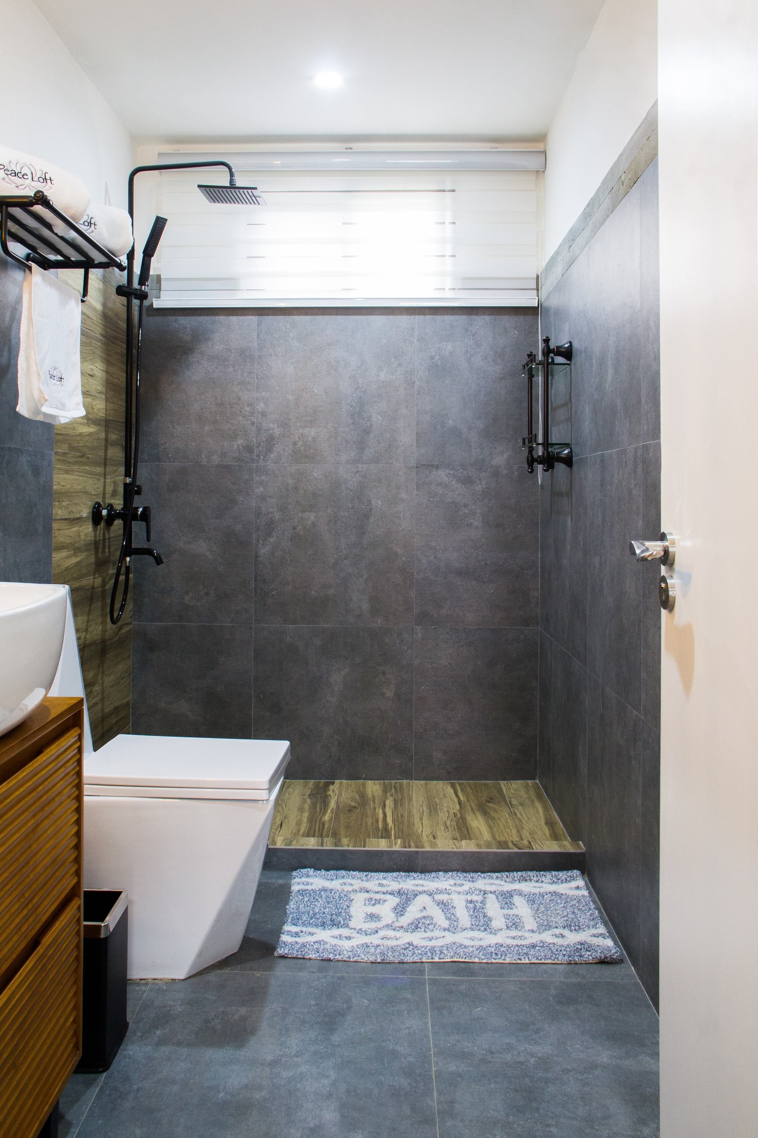 A modern bathroom with a shower, toilet, and sink.