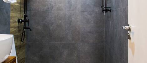 A modern bathroom with a shower, toilet, and sink.