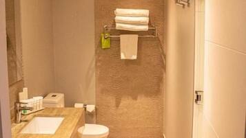 Een kleine badkamer met een wastafel, toilet en handdoekhouder.
