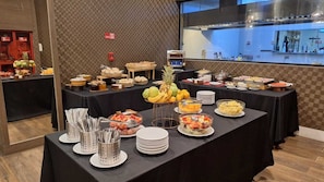 A buffet setup with various food items and utensils.