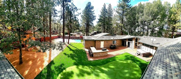 Enjoy a backyard with a lawn, patio, and pool, surrounded by tall trees.