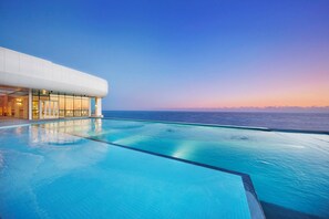 A modern hotel with a pool overlooking the ocean at sunset. - Skybay Hotel Gyeongpo (Gangneung)