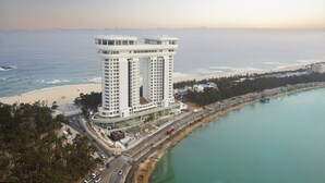 A high-rise hotel with a modern design, located near a beach and a body of water. - Skybay Hotel Gyeongpo (Gangneung)
