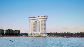 Un hotel moderno y alto de diseño cilíndrico peculiar, situado cerca de la costa con vistas claras al mar.