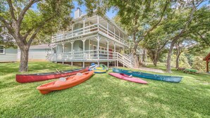 A two-story building with a porch and a staircase leading to the upper level. - Players Place PRD2462 (New Braunfels)
