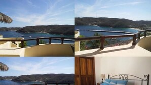 A hotel room with a balcony overlooking a coastal view, a bed with striped bedding, and a wooden door. - Villa Punta Sta Cruz 3BR (Santa María Huatulco)