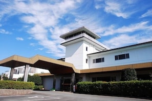A modern building with a flat roof and a central tower.