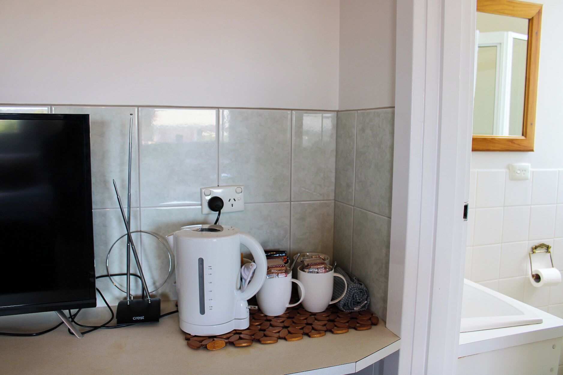 A kitchenette with a coffee maker, a toaster, and a TV.