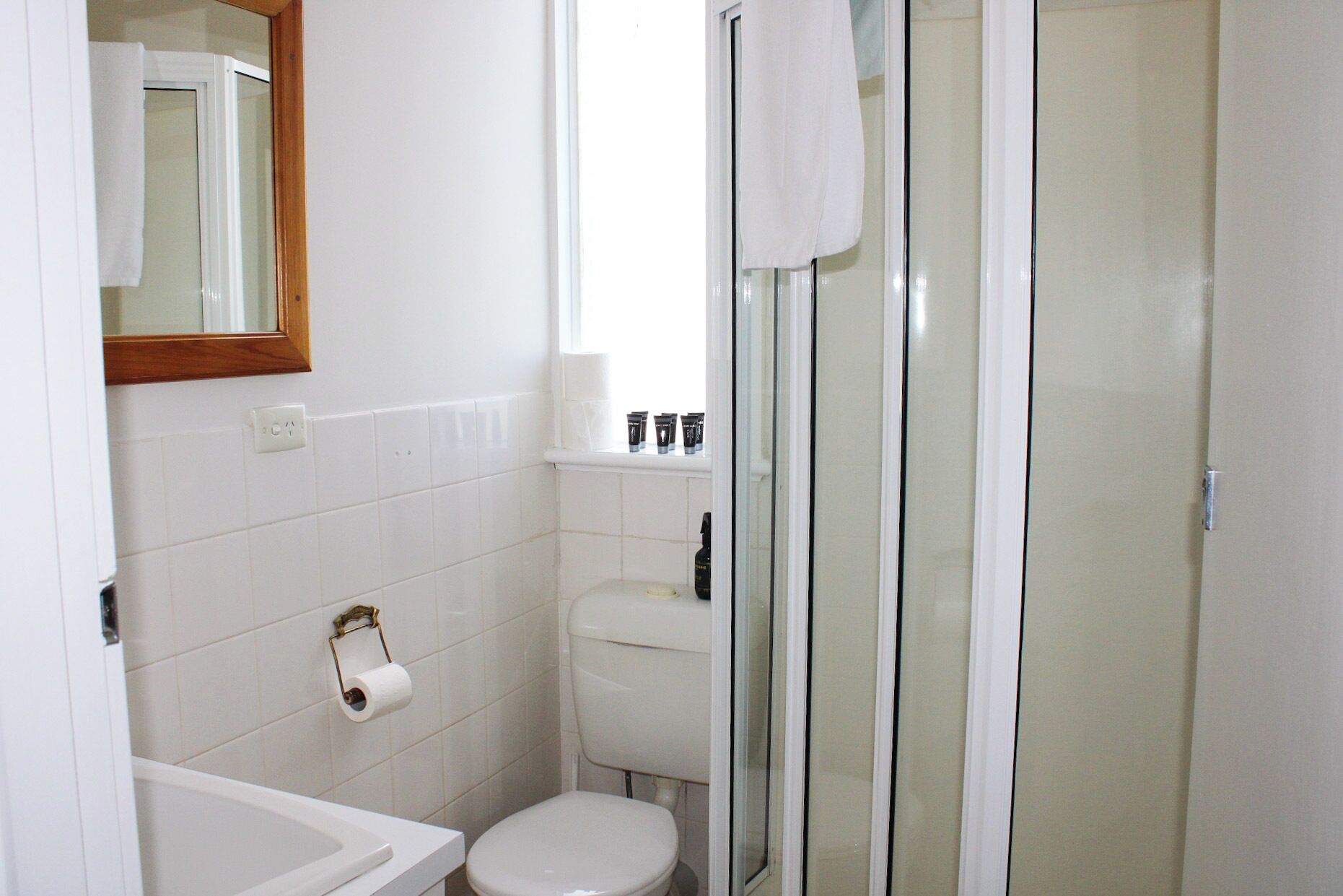 A bathroom with a toilet, sink, and shower.