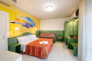 Habitación de hotel con una cama, dos mesitas de noche, un escritorio y una silla.