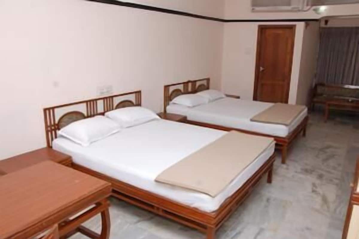 Ein Hotelzimmer mit zwei Holzbett, einem Schreibtisch aus Holz und einem Kleiderschrank.