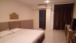 A hotel room with a large bed, a desk, a TV, and a wardrobe. - Tongpoon Hotel (Bangkok)
