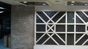 A modern interior with a geometric patterned wall, recessed ceiling lights, and a marble floor. - Tongpoon Hotel (Bangkok)
