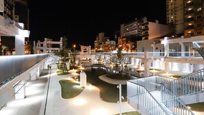 A well-lit outdoor area with a central water feature, surrounded by pathways and seating areas. - Hotel Initial-Beer (Tainan)