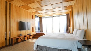 A modern hotel room with wooden paneling, a large bed, a flat-screen TV, and a window with curtains. - Hotel Initial-Beer (Tainan)