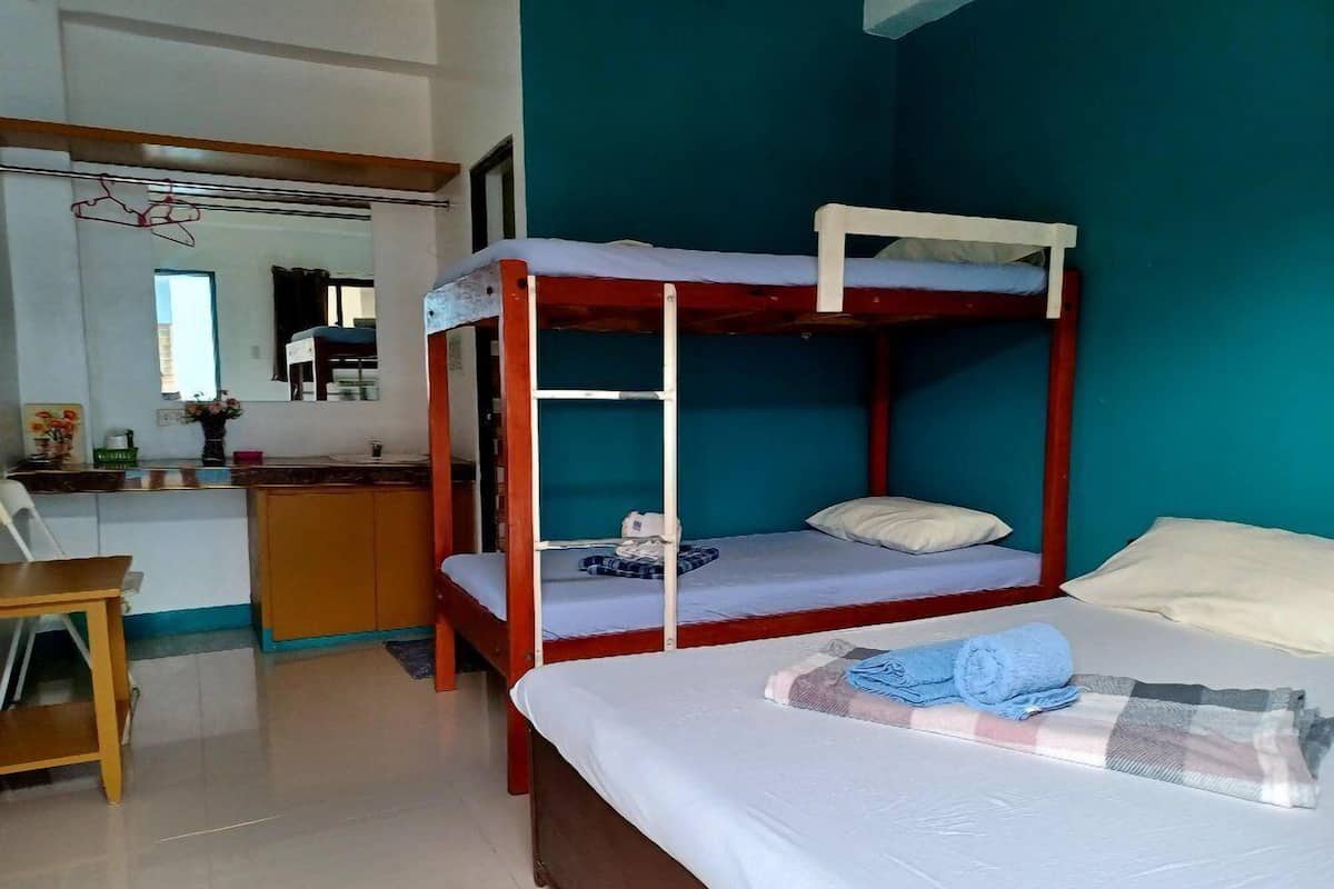 A bunk bed room with a desk and a chair.