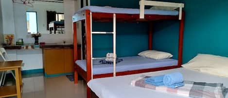 A bunk bed room with a desk and a chair.