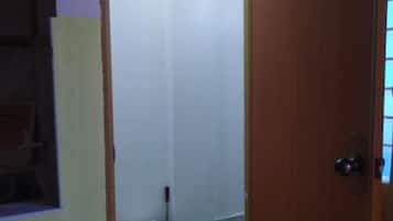 Et badeværelse med toilet, moppe og dør.