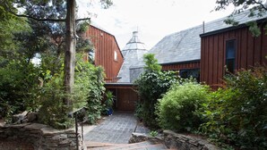A rustic wooden building with a stone staircase leading to a wooden door. - Kauri House (Wanaka)