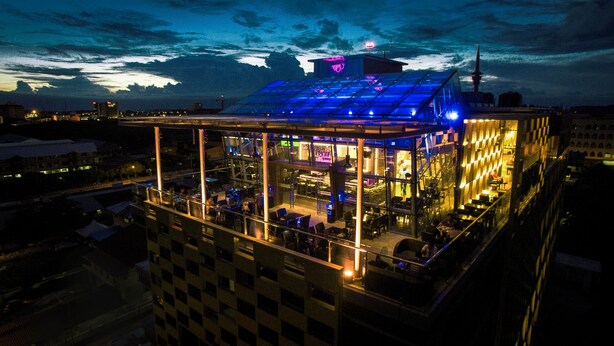 A modern building with a glass facade, multiple levels, and a rooftop terrace. - Hotel Labuan Point (Labuan)