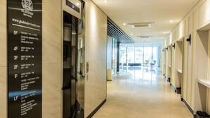 A hotel lobby with a clear floor plan on the wall, indicating guest rooms, a lobby, and a business center.