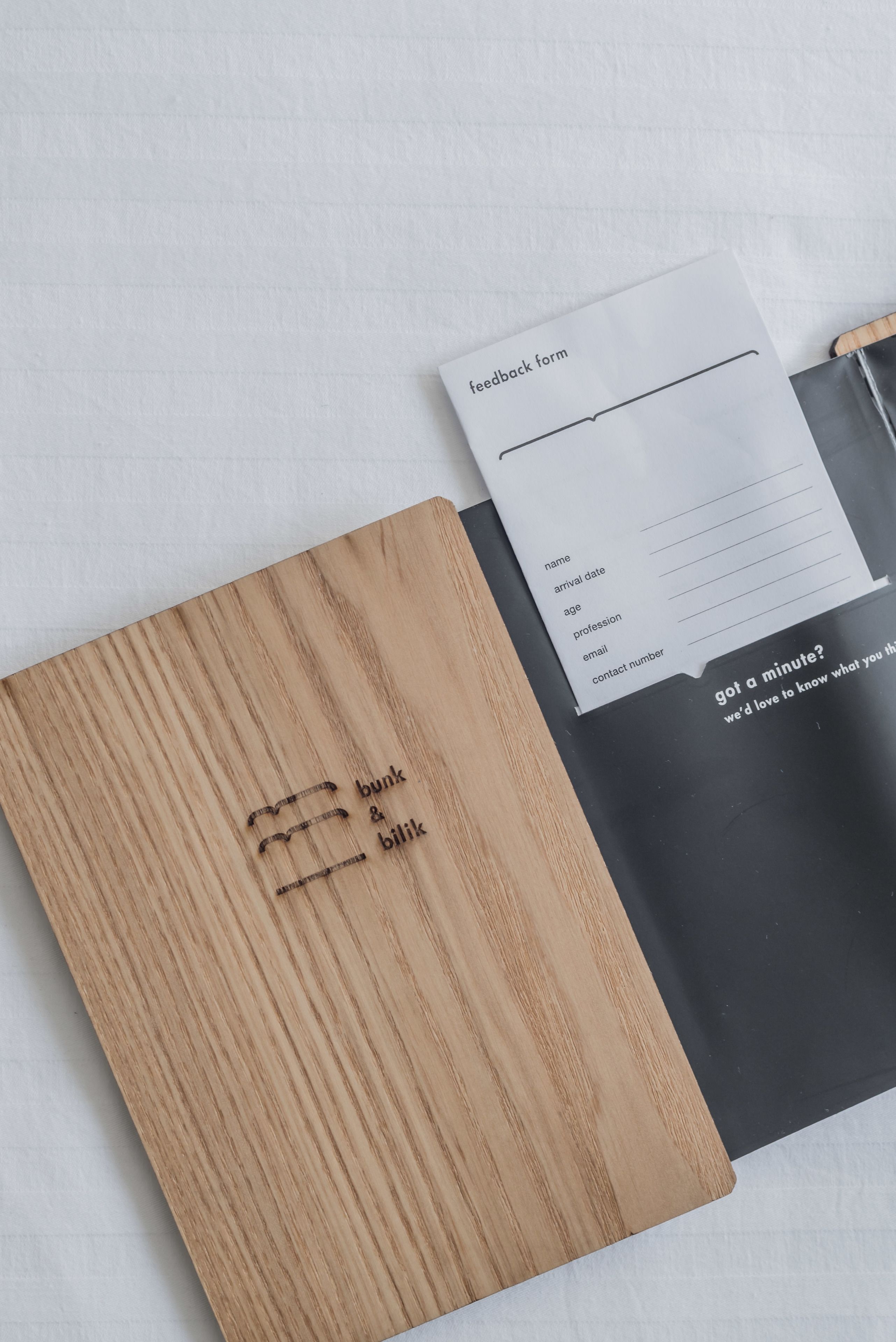 A wooden folder with embossed text and a feedback form on a white background.