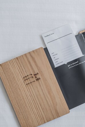 Una carpeta de madera con texto en relieve y un formulario de retroalimentación sobre un fondo blanco.