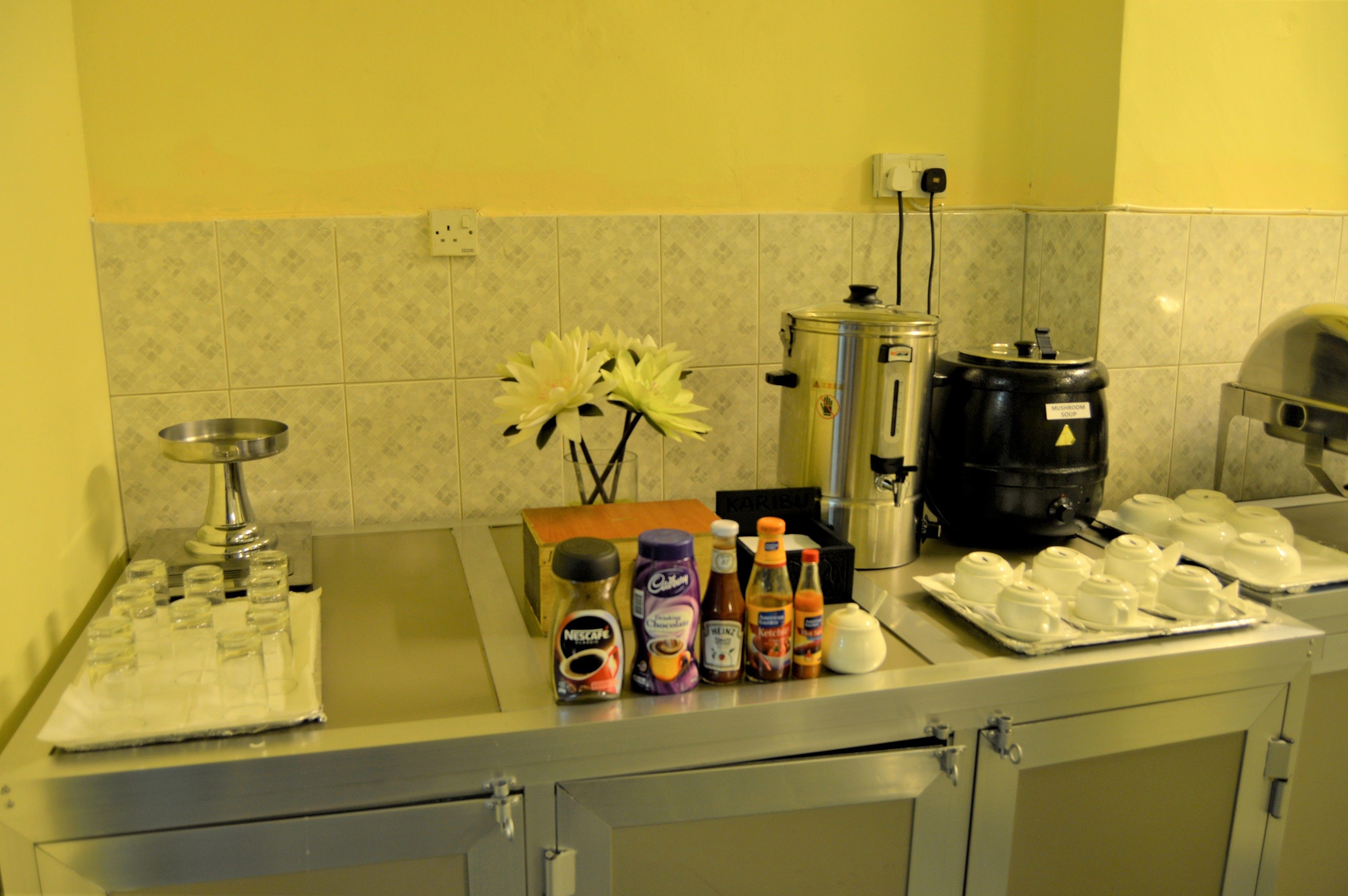 A kitchen counter with various items including a coffee maker, a kettle, and condiments.