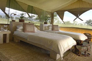 A tent-style room with two beds, a table with a pitcher, and a view of the outdoors. - Kicheche Bush Camp (Maasai Mara)