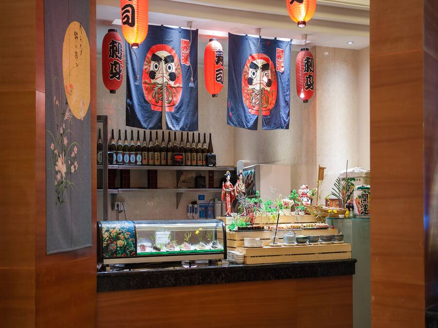 Interior de un restaurante con decoración tradicional, que incluye faroles japoneses y caligrafía.