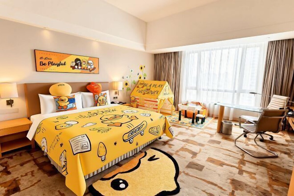 Ein Hotelzimmer mit einem Bett, einem Schreibtisch, einem Stuhl und einem großen Fenster.